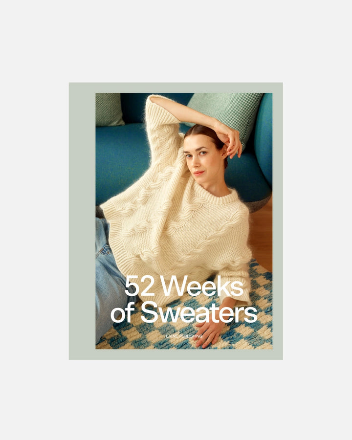 Woman wearing a white sweater with '52 Weeks of Sweaters' text on a light gray background