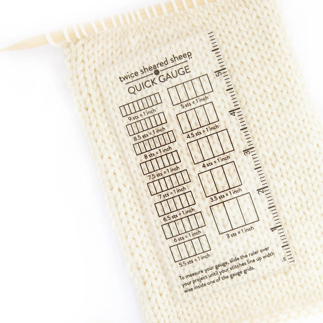 Knitting gauge swatch with printed measurement chart on a white background