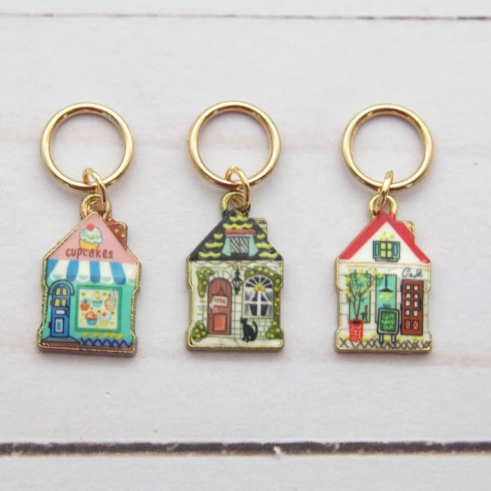 Three colorful house-shaped keychains on a white background