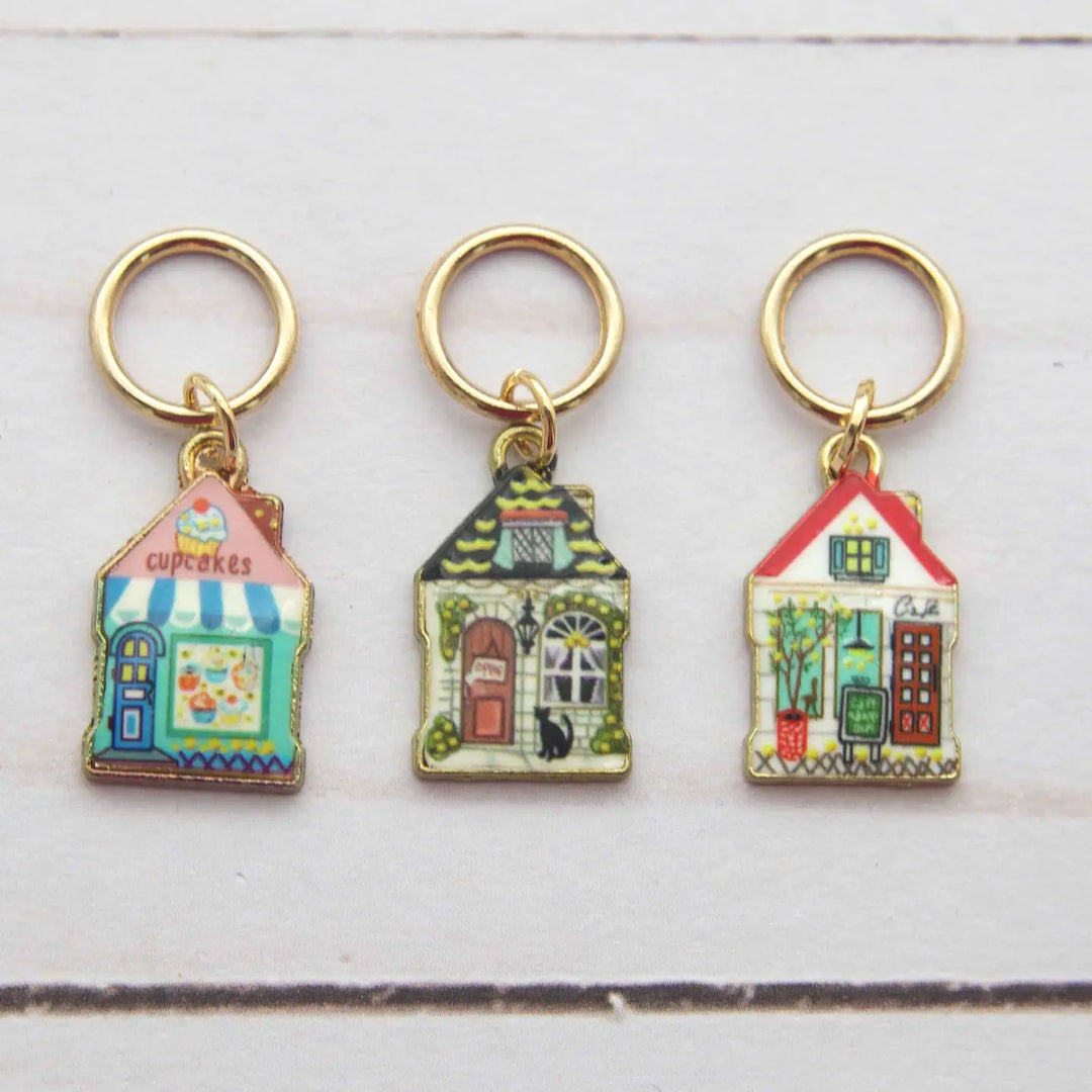 Three colorful house-shaped keychains on a white background