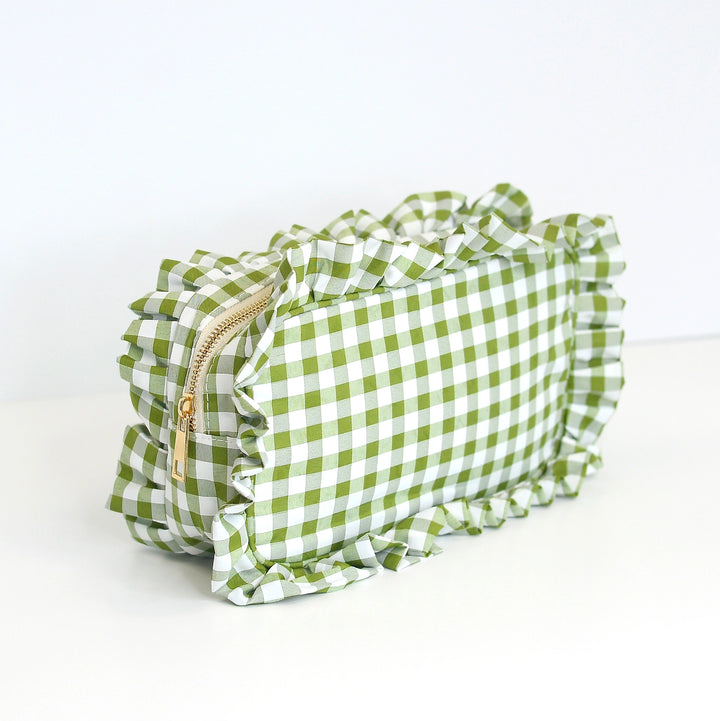 Green and white checkered pouch with a gold zipper on a white background