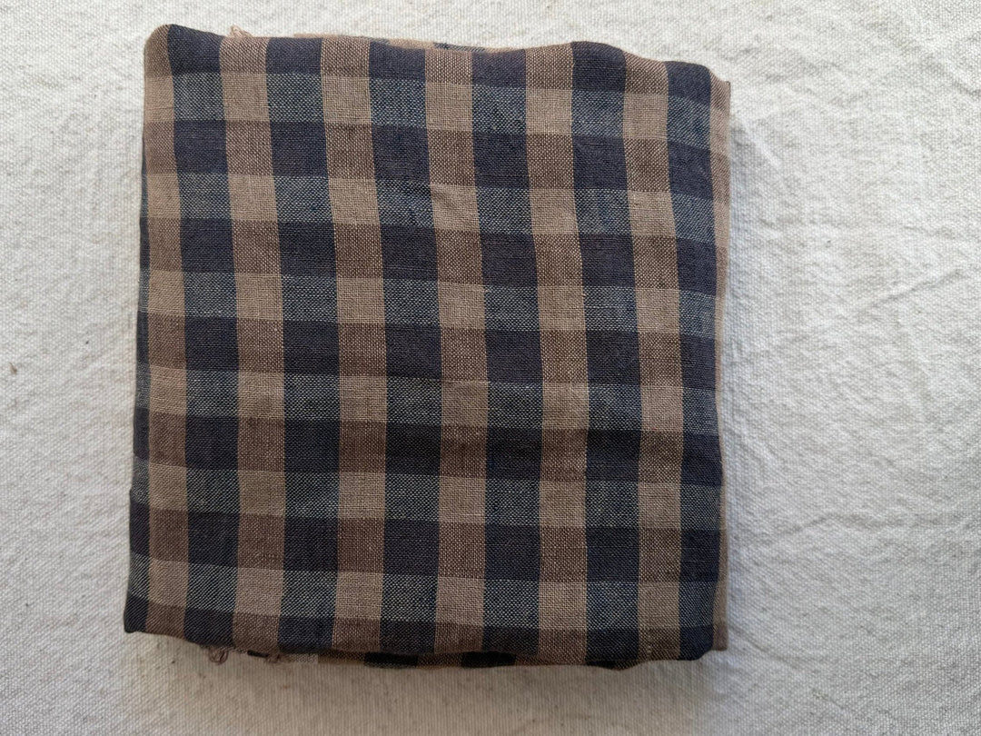 Wide tan, brown and navy checked fabric on a linen background.  