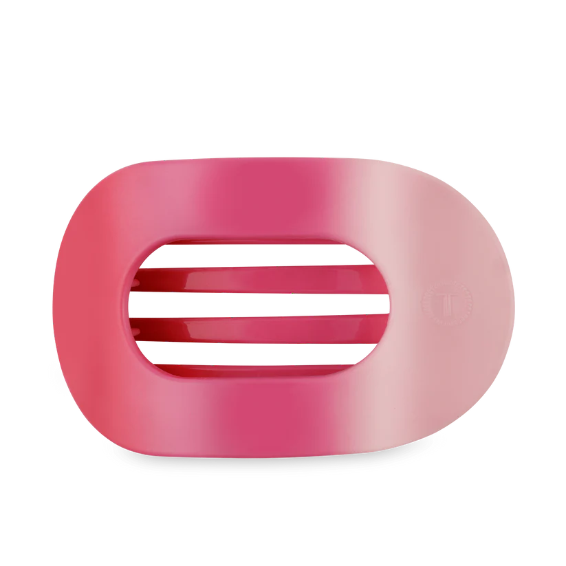 Pink plastic clip with a central slit on a white background
