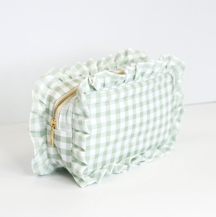 Light green and white checkered pouch with a gold zipper on a light gray background