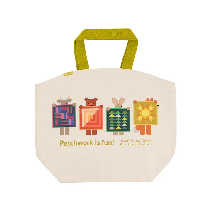 Beige tote bag with colorful patchwork design and text on a white background